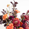 This captivating floral arrangement exudes a vibrant, autumnal energy, filled with bold