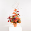 This elegant floral arrangement captures a dynamic balance of form and color