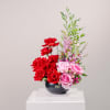 This stunning floral arrangement showcases an artful blend of graceful forms and