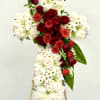 A heartfelt floral cross crafted with pure white blooms, accented by a