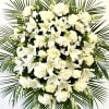 An elegant standing spray of white roses, lilacs, and snapdragons symbolizes purity