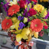 Lilies, roses, gerbera daisies, stock, statice, solidago, daisies, and wax flower.