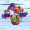 oranges and purples in an orange glass jar.
