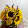 Sunflowers in a cylinder with berries and yellow accents