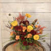 A lovely desktop bouquet with fall flowers and accented with acorns.
