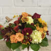 Fall flowers arranged in a white ceramic pumpkin
