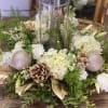 Elegant round centerpiece centered with a hurricane vase and floating candle