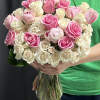 A gorgeous bouquet featuring white, blush, and pink roses, along with spray