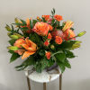 A monochromatic mix of oranges that includes pin-cushion protea, free spirit roses