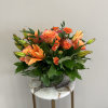 A monochromatic mix of oranges that includes pin-cushion protea, free spirit roses