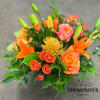 A monochromatic mix of oranges that includes pin-cushion protea, free spirit roses