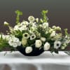 An eye-catching centerpiece of panda anemone, scabious, astilbe, freesia, ranunculus, stock, roses