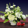 A grand centerpiece with a combination of ranunculus, anemones, hydrangeas, roses, and
