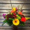 Colored glass vase filled with designer&#039;s choice of autumn/seasonal flowers. Each one