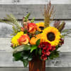 An ensemble of beautiful fall flowers with the mini pumpkin. 