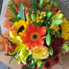 Hand tied bouquet consist of assortment of fall flowers wrap in tissue
