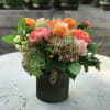 Orange and peach roses, orange dahlias, peach hypericum berries and green hydrangea