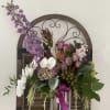 Silver tall vase with purple and white flowers.