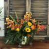 Here we have a sphere vase decorated with sunflowers, orange orchids, and
