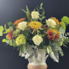 Beautiful Eggshell ceramic vase filled with fall blooms and greenery.