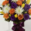 Assortment of autumn colors with roses, lilies, carnations and spruced with greens
