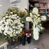 Funeral pack, large floral arrangement on base, and cross-shaped crown with natural