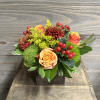 A cute arrangement of bright fall flowers in a wooden box, perfect