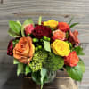A textured bouquet of fall themed roses with accenting flowers.