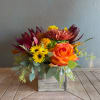 Bringing the rustic warmth of the season into your home, this arrangement