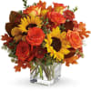 Sunny sunflowers and radiant roses in a happy orange cube vase bring