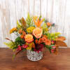 Welcome autumn colors into your home with this small vibrant flower arrangement.