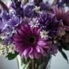 A bouquet of in season flowers in a variety of purple and
