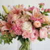 A bouquet of in season flowers in a variety of pink &amp;