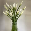 A refined design featuring fresh, elegant calla lilies paired with lush greenery