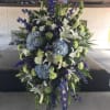 Blue and white elegant funeral arrangements on a standing spray honoring the