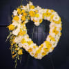 Sympathy heart made with a variety of yellow flowers in the base