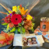 A floral arrangement designed in a cube with bright Fall colored flowers