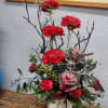 Cool white skull vase with black accents and deep red carnations. 