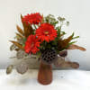Bold, fiery red gerbera daisies take center stage in this striking design