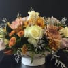 An inviting arrangement filled with blooms in spiced tones, perfect for setting