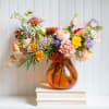 Luxurious scarlet and garnet blooms meet golden undertones in this artful arrangement.