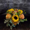 &ldquo;Amaretto Twist&rdquo; is a cheerful fall bouquet featuring golden sunflowers, orange roses