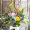 King Protea, Pin-Cushion Protea, Thistle, unique seasonal accents and foliage arranged in