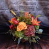 &quot;Pumpkin Spice&quot; is a cozy autumn-inspired arrangement featuring vibrant orange lilies, golden