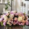 Nestled in a rustic wooden box, delicate lavender chrysanthemums, pristine white roses