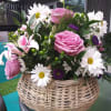 A handled basket filled with, roses, pink stargazer lillies, daisy mums, Monte