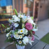 A handled basket filled with, roses, pink stargazer lillies, daisy mums, Monte