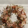 This Wreath is filled with a variety of tones of peach, orange