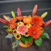 A warm gathering of gerbera daisies, mums, spray roses, carnations and a