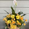Send your condolences with this peace lily in a basket filled with
